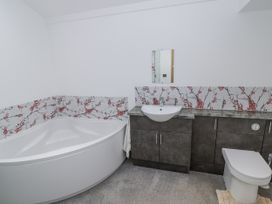 A bathroom with a bathtub, sink and toilet at Owl Barn in Banbury