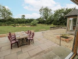 An outdoor patio with a dining table and chairs at Owl Barn Banbury