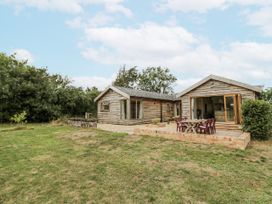 An outdoor view of a house with a table and chairs at Owl Barn in Banbury