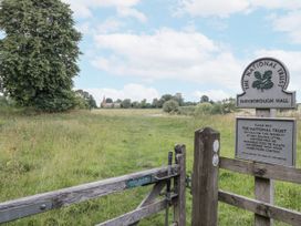 A grassy area with a gate and a sign at Farnborough Hall in Banbury