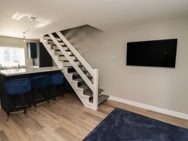 A living room with a staircase and kitchen island at 3 Longstone Park Beadnell