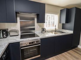 A kitchen with cabinets, sink, and appliances at 3 Longstone Park Beadnell