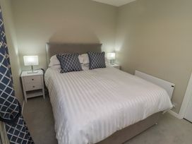 A bedroom with a bed and lamps on nightstands at 3 Longstone Park Beadnell