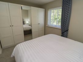 A bedroom with a bed and wardrobe at 3 Longstone Park Beadnell