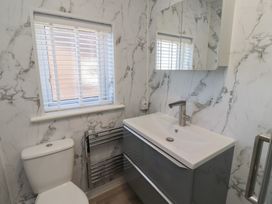 A bathroom with sink, toilet, and mirror at 3 Longstone Park Beadnell