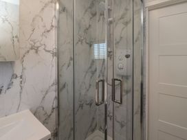 A shower with glass enclosure in a bathroom at 3 Longstone Park Beadnell