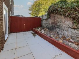 A patio with a red fence and a garden bed at 3 Longstone Park Beadnell