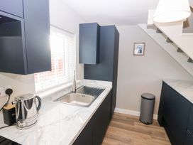 A kitchen with a sink and kettle at Seaspray in Beadnell