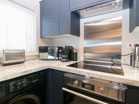 A kitchen with appliances including a washing machine and coffee machine at Seaspray in Beadnell
