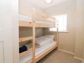 A bedroom with a bunk bed and window at Seaspray in Beadnell