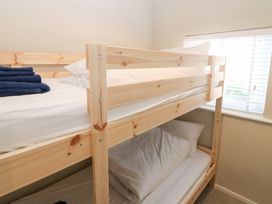 A bunk bed with blue towels and pillows at Seaspray in Beadnell