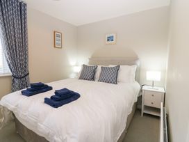 A bedroom with a bed and bedside table at Seaspray in Beadnell