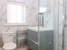 A bathroom with a sink, toilet, shower, and towel radiator at Seaspray in Beadnell
