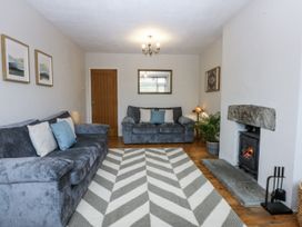 A living room with a sofa and fireplace at 1 Maes Y Ffynnon in Llandegfan