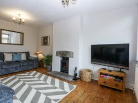 A living room with a fireplace and a television at 1 Maes Y Ffynnon in Llandegfan