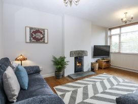 A living room with a fireplace and television at 1 Maes Y Ffynnon, Llandegfan