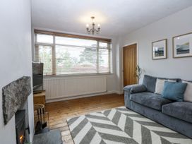 A living room with a sofa and television at 1 Maes Y Ffynnon in Llandegfan