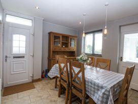 A dining room with a table and chairs at 1 Maes Y Ffynnon in Llandegfan
