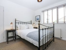 A bedroom with a bed and bedside tables at 1 Maes Y Ffynnon in Llandegfan