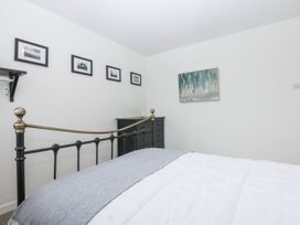 A bedroom with a bed and wall decor at 1 Maes Y Ffynnon in Llandegfan