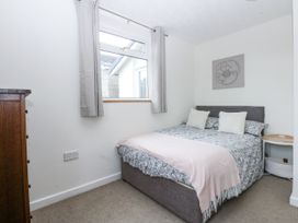 A bedroom with a double bed and a nightstand at 1 Maes Y Ffynnon Llandegfan