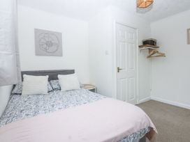 A bedroom with a bed and wall art at 1 Maes Y Ffynnon in Llandegfan