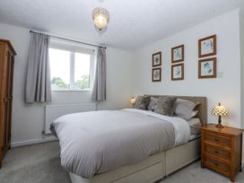 A bedroom with a bed and wardrobe at 1 Maes Y Ffynnon in Llandegfan