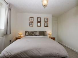 A bedroom with a bed and pictures on the wall at 1 Maes Y Ffynnon in Llandegfan