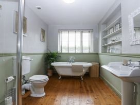 A bathroom with a bathtub, toilet, and sink at 1 Maes Y Ffynnon in Llandegfan