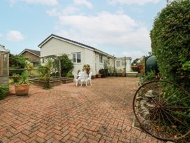 An outdoor area with a garden table and chairs at 1 Maes Y Ffynnon in Llandegfan