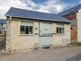An exterior view of a cottage featuring a stone wall and slate roof at Firefly Cottage
