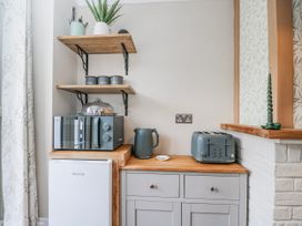 A kitchen area with appliances and storage at Firefly Cottage
