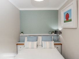 A bedroom with a bed and nightstand at Firefly Cottage