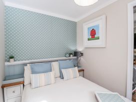A bedroom with a bed and decorative wall at Firefly Cottage