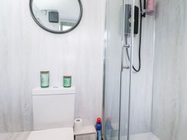 A bathroom with a toilet and shower at Firefly Cottage