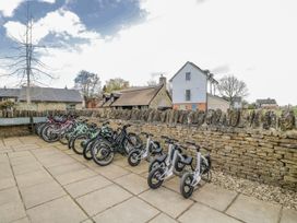 A row of bicycles and balance bikes near a stone wall at Firefly Cottage 