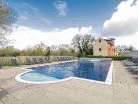 An outdoor swimming pool surrounded by lounge chairs at Firefly Cottage