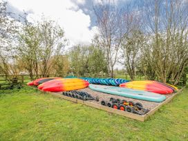 A collection of kayaks and paddle boards in an outdoor area at Firefly Cottage