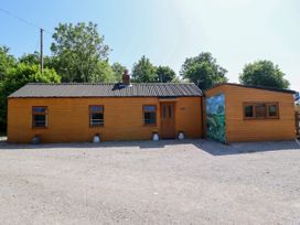 A wooden house with a mural and a gravel area at Haven in Lloc near Holywell