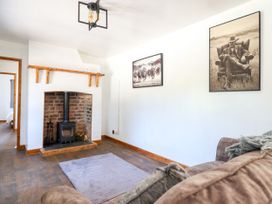 A living room with a fireplace and photographs at Haven Lloc near Holywell