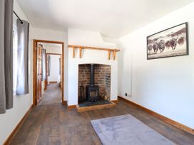 A living room with a fireplace and stove at Haven in Lloc near Holywell