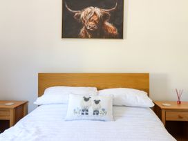 A bedroom with a bed and artwork on the wall at Haven in Lloc near Holywell