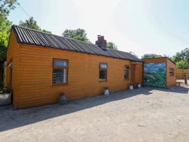 An exterior view of a wooden house with a mural at Haven in Lloc near Holywell