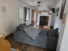 A living room with a sofa and fireplace at Hafan Bach in Lloc near Holywell