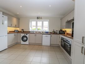 A kitchen with white cabinets and appliances at Woodlark