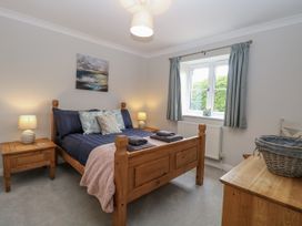 A bedroom with a bed, bedside tables, and a window at Woodlark