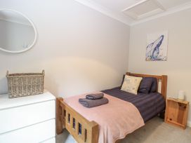 A bedroom with a bed and a mirror at Woodlark 