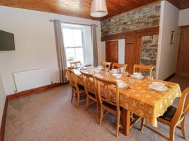 A dining room with a long table set for a meal at The Sycamores in Llawhaden near Narberth