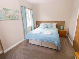 A bedroom with a bed and nightstand at The Sycamores in Llawhaden near Narberth