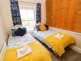 A bedroom with two single beds and a window at The Sycamores in Llawhaden near Narberth